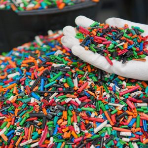 a man's gloved hand holds pieces of plastic