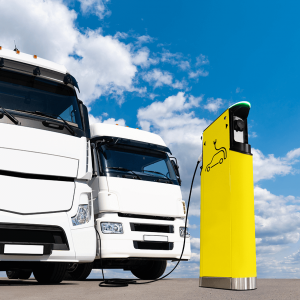 two electric trucks are charged with electricity