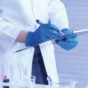 man in doctor suit with blue gloves writing something on paper
